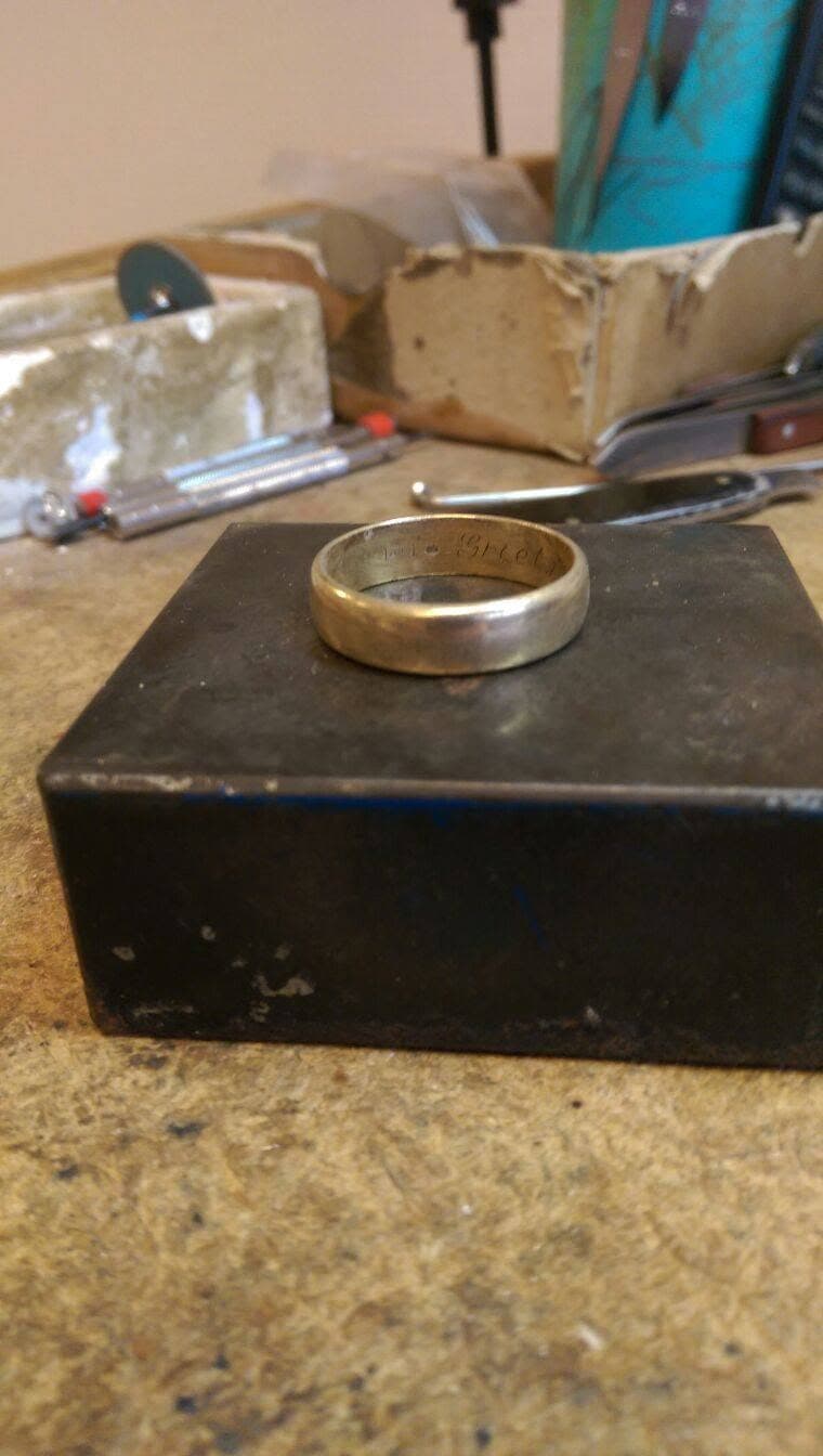 Gouden ring op het aambeeld aan de werkbank