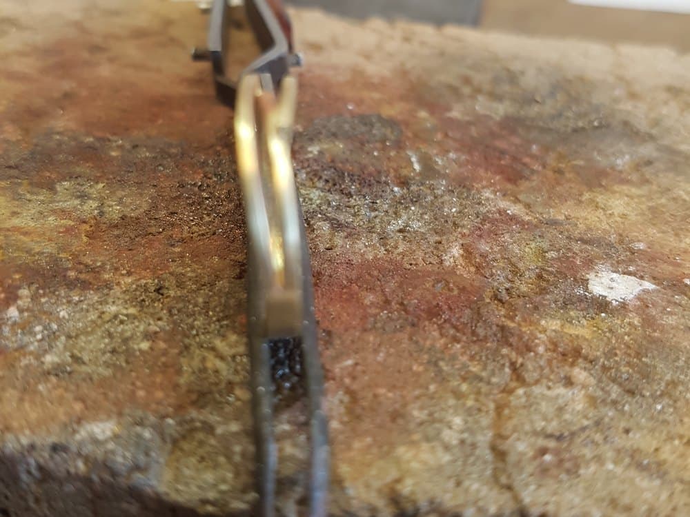 Soldeertang met een ring op de soldeersteen aan de werkbank
