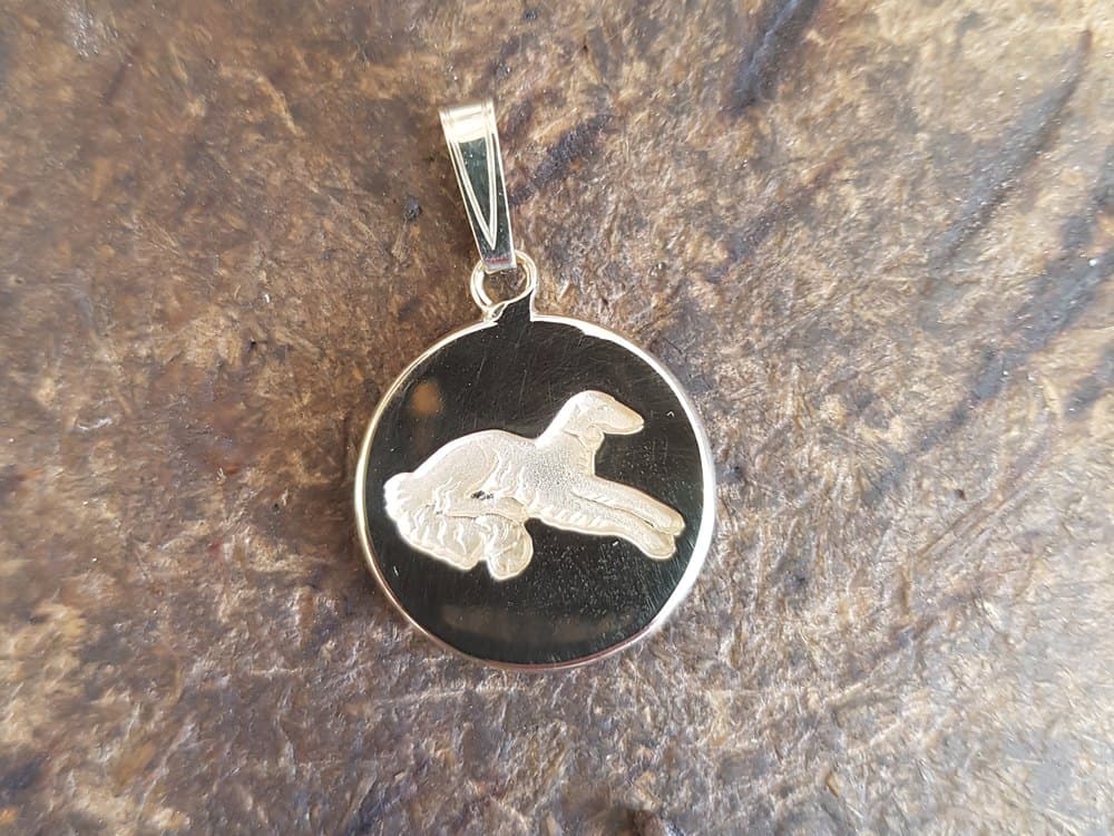 Ronde gouden hanger met een uitgezaagd silhouet van een hond