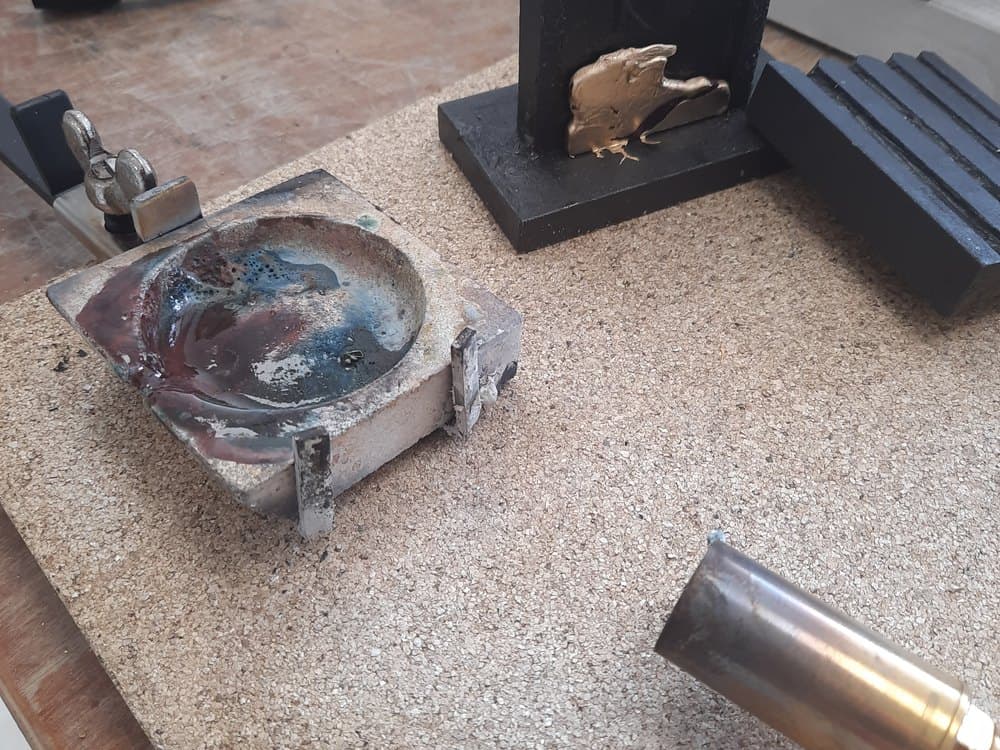 Werkbank met een smeltkroes, vijlen en een standaard met een gouden figuurtje